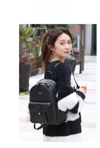 Gros plan d'un grand sac à dos en cuir noir avec détails dorés et porte-clés en fourrure