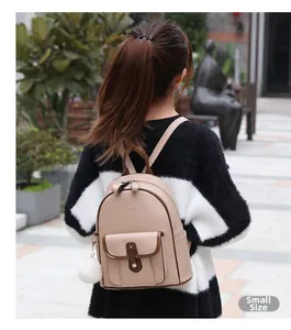 Vue détaillée du petit sac à dos en similicuir kaki avec un pompon blanc porté au dos