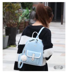 Détail du petit sac à dos bleu clair en cuir souple avec bordure blanche et pompon