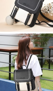 Close-up of rose embossed flap and black-white contrast panels on a stylish backpack