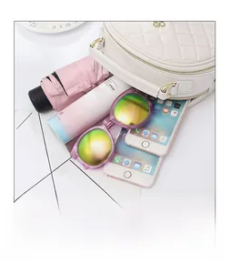 Internal view of beige quilted round bag showing capacity for umbrella, phones, and sunglasses