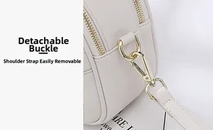 Macro shot of detachable golden metal hook and fine stitching on beige leather bag