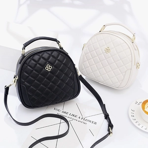 Quilted semi-circle crossbody bag for women with gold flower clasp in black and cream
