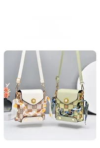 Detail view of mini checkerboard crossbody bags with pearl buckles and floral silk scarves