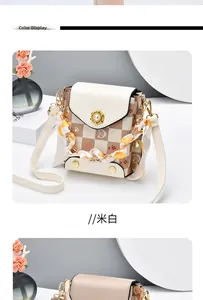 Detail of cream mini crossbody bag with cat paw pattern and pearl flower clasp