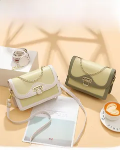 Détail de sacs à bandoulière imprimés avec chaîne dorée et sangle bohème sous une lumière douce