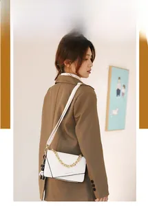 Dettaglio della piccola borsa bianca a tracolla con catena dorata e charm panda