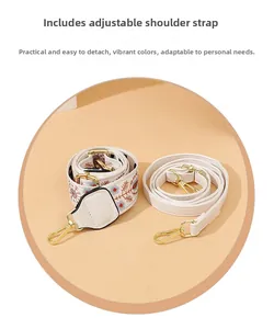 Dettaglio della tracolla ricamata con fiori e cinturino in pelle bianca con ganci dorati