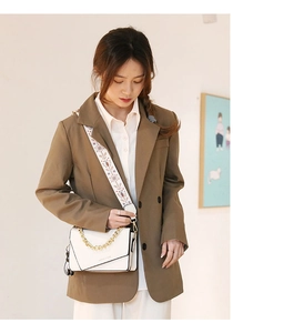 Dettaglio borsa bianca con tracolla etnica ricamata e catena dorata elegante