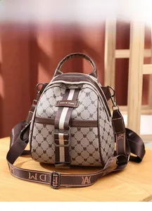 Detail of monogrammed canvas crossbody bag with wide strap and premium hardware