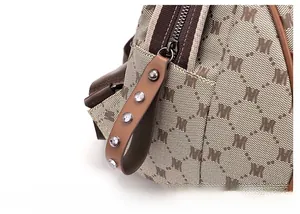 Detailed close-up of premium leather zipper pull with silver studs on M-pattern backpack