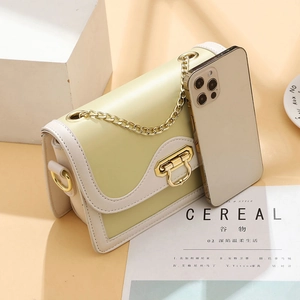 Petit sac bandoulière imprimé vert et crème avec chaîne dorée et smartphone pour comparer la taille