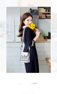 Detail of checkered crossbody bag with pearl handle and stylish wide letter strap