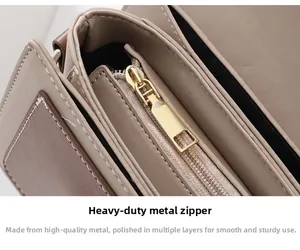 Detailed close-up of premium gold hardware zipper and lychee grain leather on small square bag