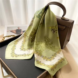 Foulard en soie vert clair à motifs floraux et bordure baroque jaune sur un sac en cuir