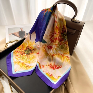 Elegant lotus leaf silk scarf with vibrant floral print draped over a stylish handbag