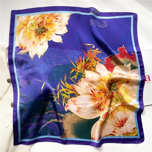 Detail of silk square scarf featuring purple gradient lotus and golden bamboo leaf prints