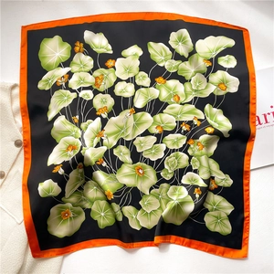 Detail of silk satin square scarf with lotus leaf print and glossy smooth texture