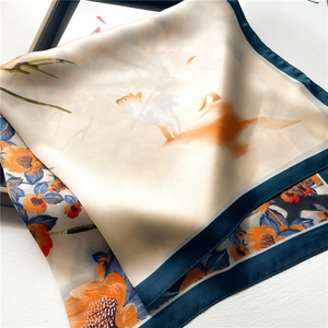 Vue détaillée d'un foulard en soie à fleurs et renard sur un plateau en bois élégant