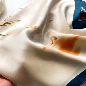 Détail d'un foulard en soie avec imprimé renard orange et bordures bleu marine