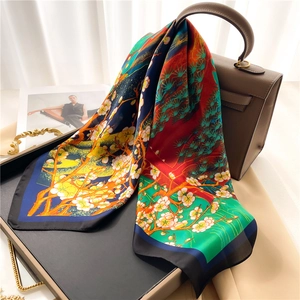 Élégant foulard en soie à imprimé floral drapé sur un sac sous une lumière douce