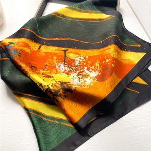 Détail de l'imprimé paysage vif et de la bordure noire sur le foulard carré en soie