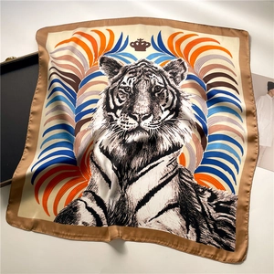 Macro detail of silk scarf featuring realistic tiger head and colorful feather patterns