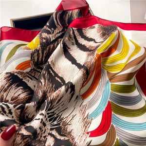 Detailed view of silk square scarf featuring realistic tiger patterns and red borders