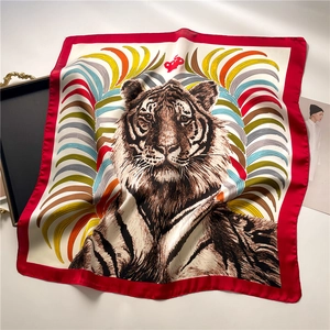 Macro view of silk scarf with realistic tiger head and vibrant feather pattern details