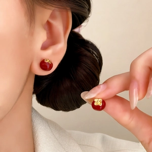 Elegant persimmon-shaped stud earrings in deep red and gold for a minimalist chic look