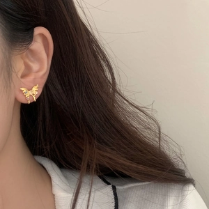 Elegant gold bow-shaped butterfly earrings with colorful zircon stones on female model