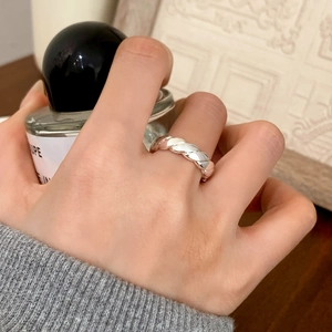 Close-up of a silver twisted rope ring featuring a classic braided texture on a finger