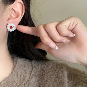 Elegant pearl flower earrings with red gemstone center shown on ear for daily style
