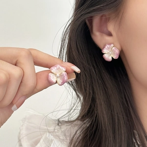 Orecchini a lobo a fiore sfumato rosa e bianco con perla indossati da una modella
