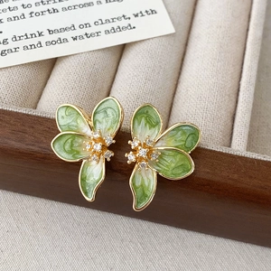 Dettaglio di orecchini a lobo a fiore in smalto verde con placcatura in oro e zircone