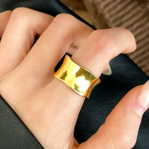 Detailed view of a wide concave gold-finished minimalist ring with a mirror-polished surface