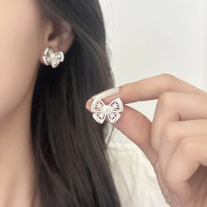 Silver hollow butterfly earrings with white zircon on female model for elegant style
