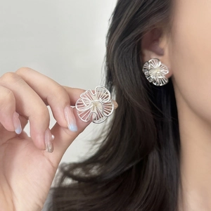 Elegant silver hollow floral stud earrings with intricate metallic woven petal texture