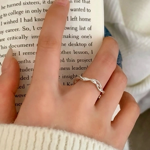 Minimalist silver wavy twisted ring for women worn on index finger in a lifestyle setting