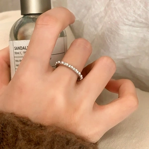 Minimalist silver ring with pearl inlay worn on hand with cozy lifestyle backdrop