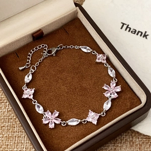 Elegant pink flower charm bracelet with marquise stones in a cozy gift box display