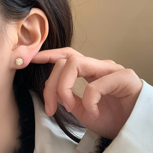 Boucles d'oreilles boules dorées élégantes avec cristaux pavés sur l'oreille