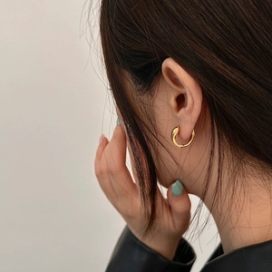 Minimalist gold hoop earrings with a thick polished finish shown on a female model