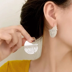 Minimalist silver geometric earrings with hollow mesh texture on female model