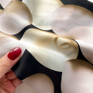 Gros plan d'un foulard en satin doux avec motifs géométriques de perles et tons dorés