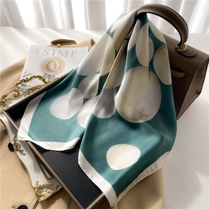 Foulard en soie style français avec motif à pois perle drapé sur un sac à main chic