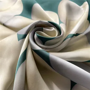 Détail d'un foulard en soie avec une texture lisse et un motif floral abstrait