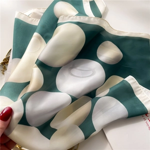 Élégant foulard en soie vert émeraude et crème à pois avec une texture satinée