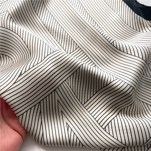 Detailed close-up of soft black and white striped silk scarf showing smooth texture