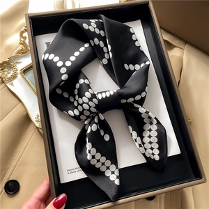Elegant black and white polka dot silk scarf presented in a premium gift box